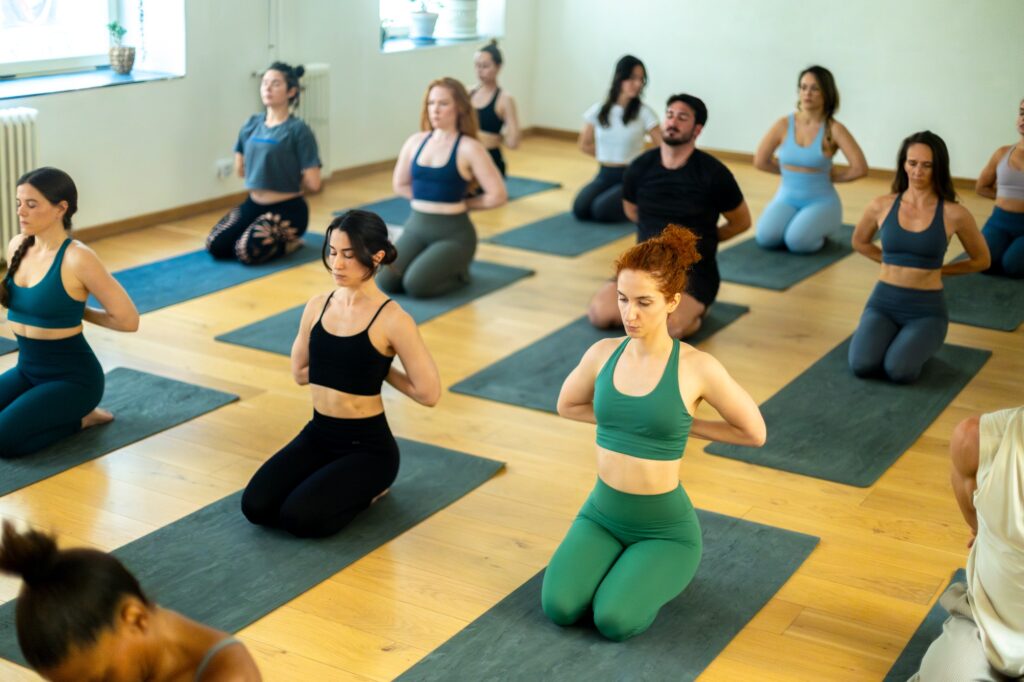 Yoga class doing reverse prayer pose in studio