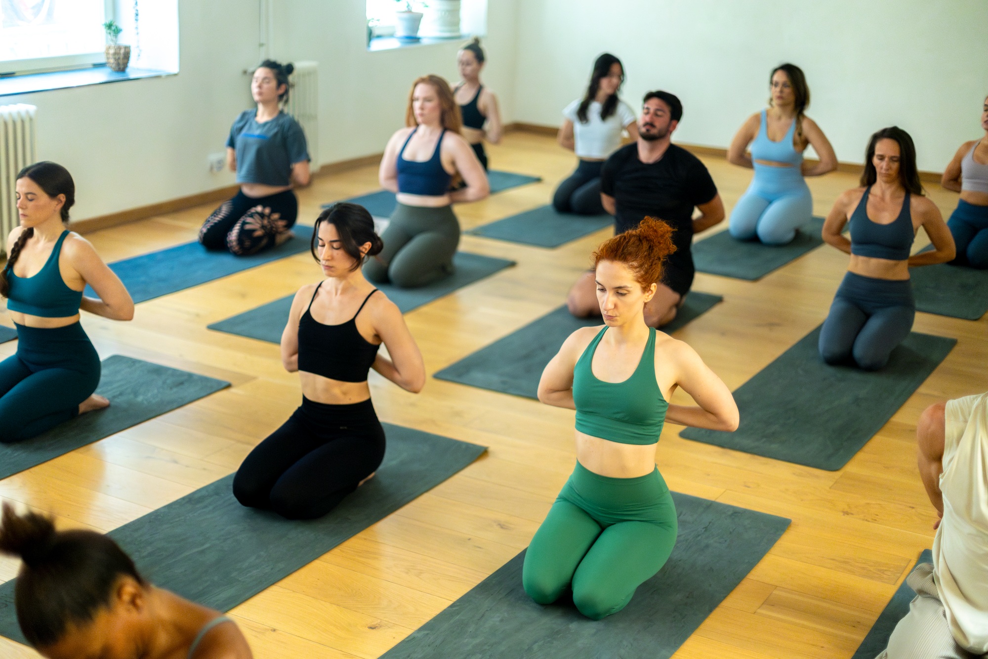 Yoga class doing reverse prayer pose in studio
