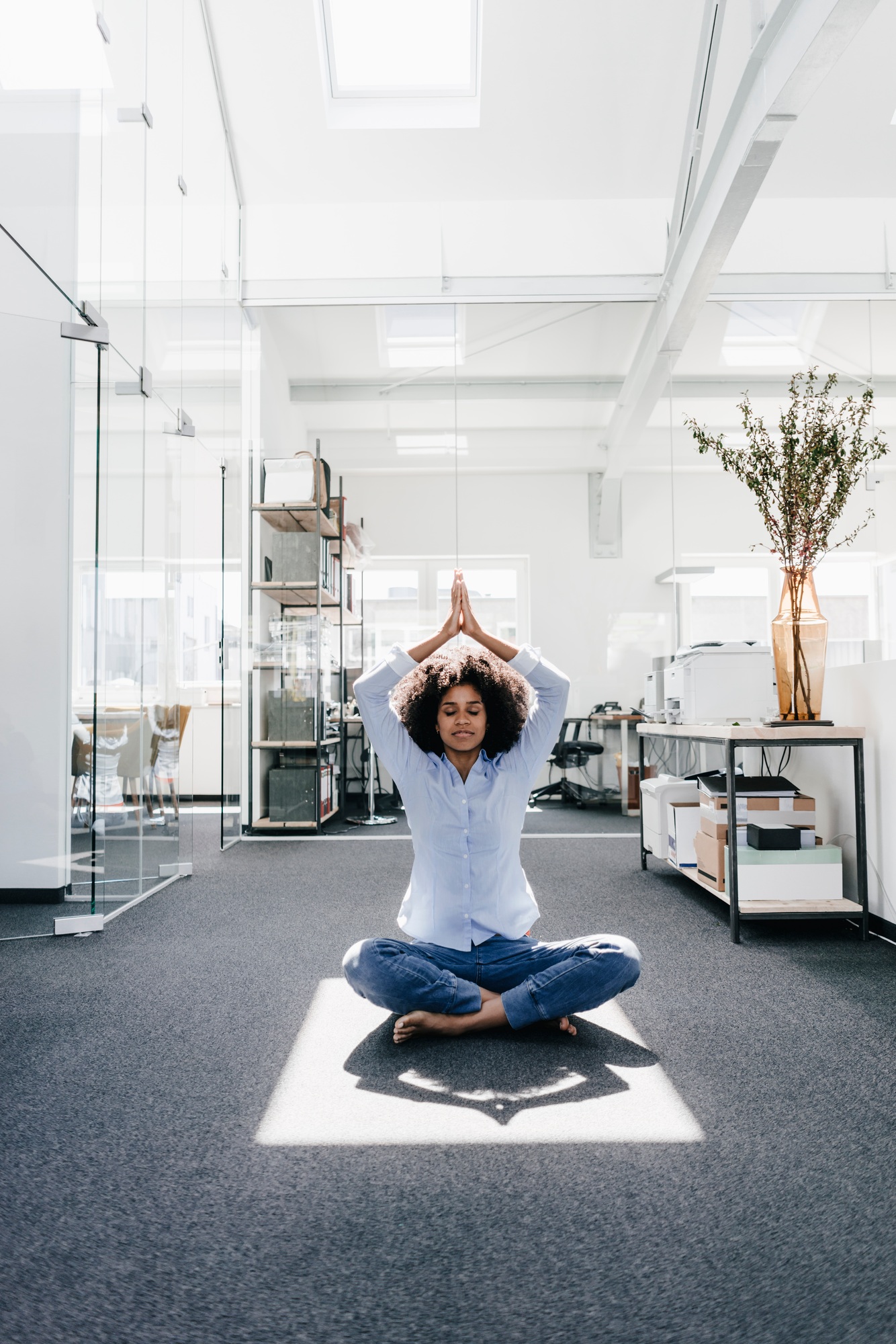 Young woman doing yoga in office
